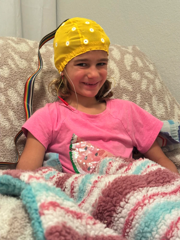 Happy child undergoing neurofeedback therapy, part of Vital Brain Performance Clinic's Brain Training Boot Camp for kids with ADHD