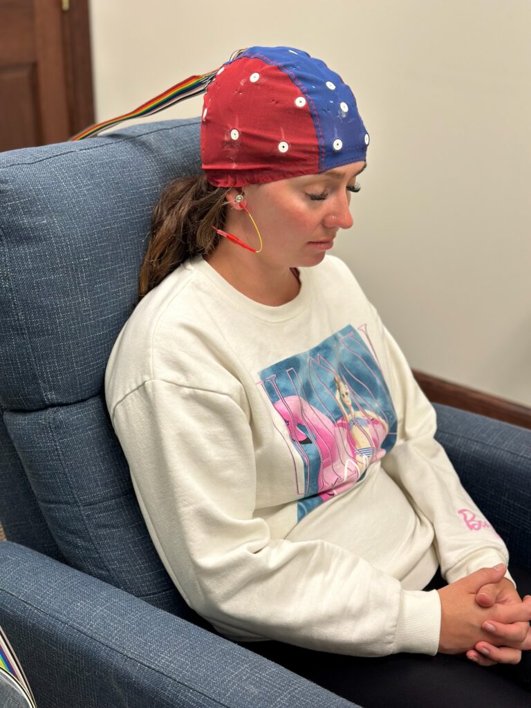 Adult undergoing a neurofeedback session, wearing EEG sensors for neurofeedback for stress tolerance