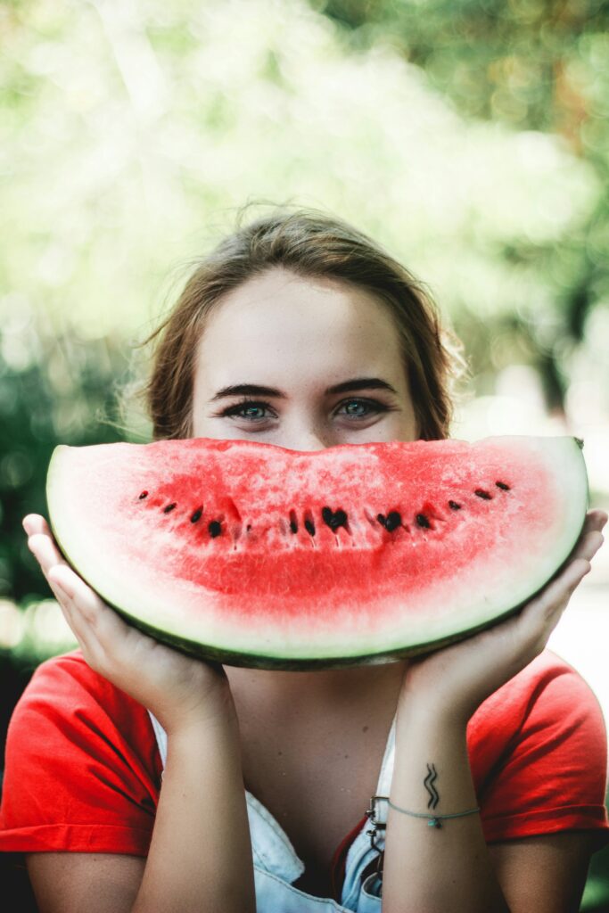 A girl holding a watermelon, representing the benefits of combining nutrition counseling and neurofeedback for managing reactive attachment disorder.