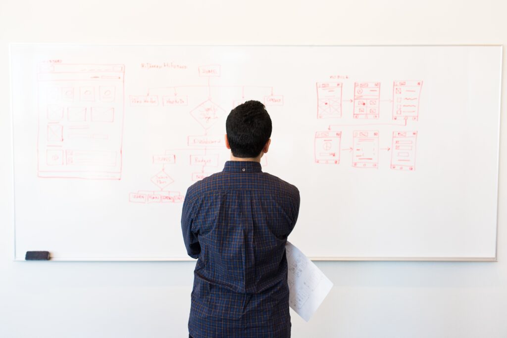 Nutrition counseling for focus is symbolized by a man at work looking intently at a whiteboard, representing enhanced concentration and mental clarity.