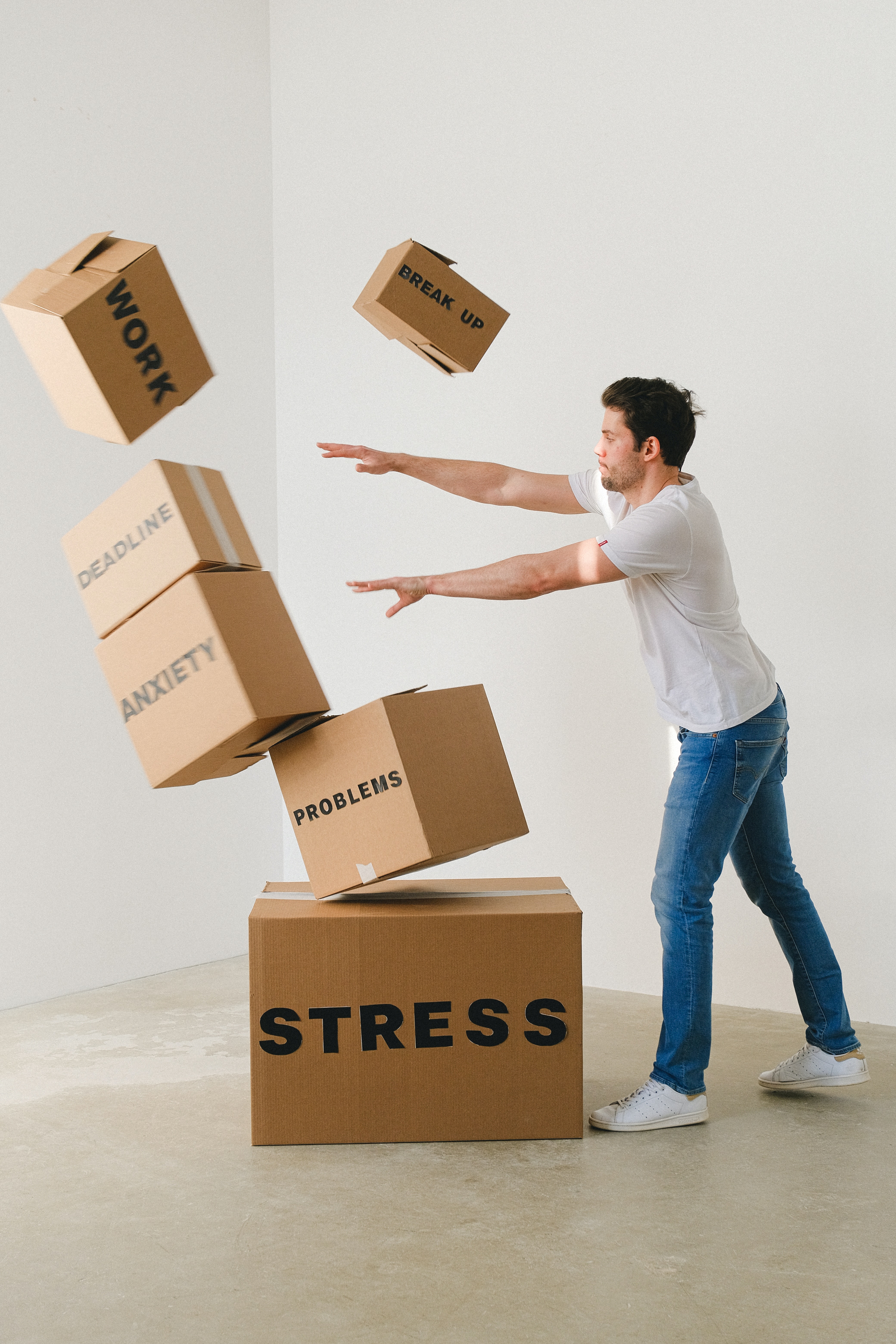 Alternative treatments for behavioral challenges are symbolized by a stressed man tossing boxes labeled anxiety, stress, work, and problems.